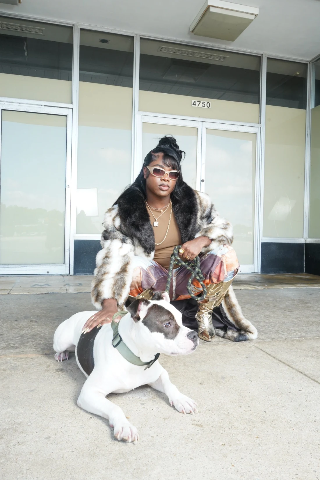 Lo-Key crouching alongside a dog during the Southside Superstar photo shoot